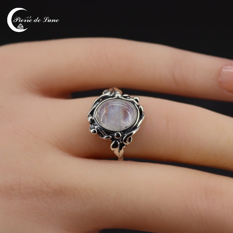 Gros plan sur la pierre de lune ovale 8x10mm de la Bague (Pléiade), monture argent massif.