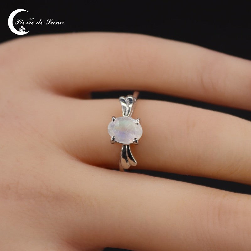Éclat scintillant de la pierre de lune facettée sur la Bague (Théia) en argent.