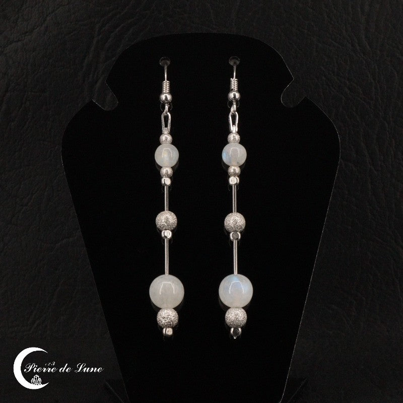 Gros plan sur une Boucle d'oreille Pierre de Lune (Perle) montrant les deux boules de pierre de lune polies.