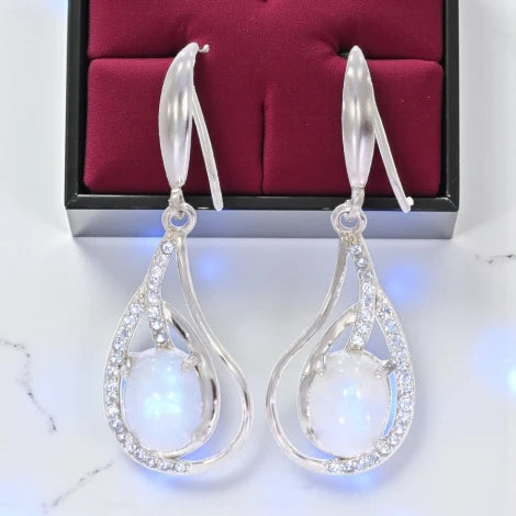 boucles créoles avec charmes en pierre de lune, look tendance, reflets nacrés