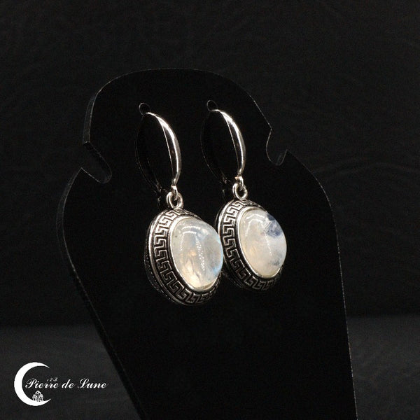 Détail d'une boucle d'oreille (Lysandre) montrant la pierre de lune ovale et l'argent émaillé