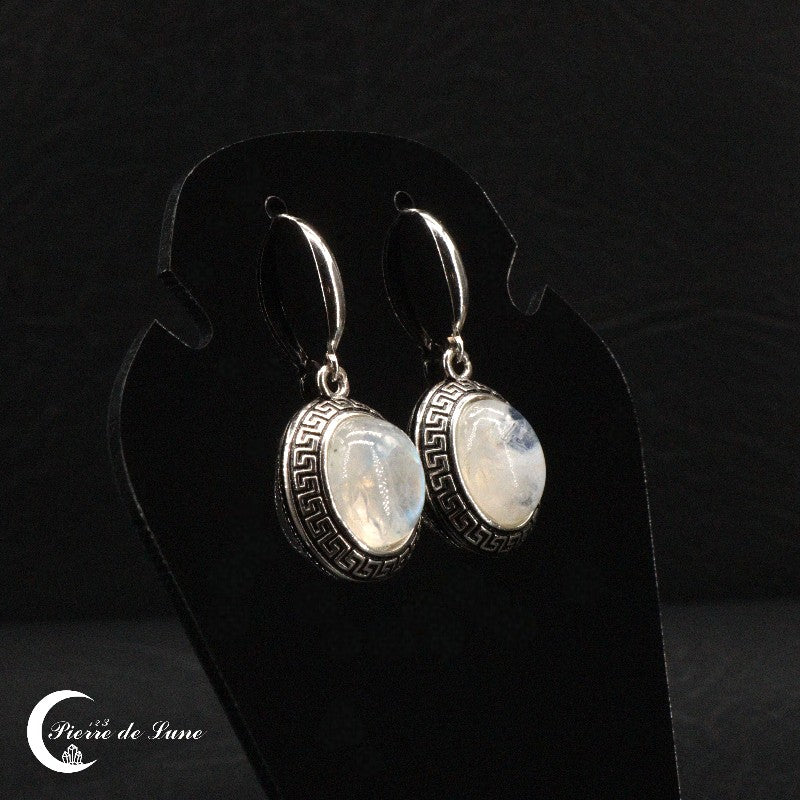 Détail d'une boucle d'oreille (Lysandre) montrant la pierre de lune ovale et l'argent émaillé