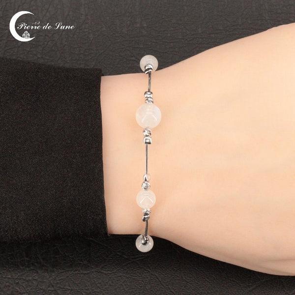 Vue rapprochée des 5 perles de lune naturelles du Bracelet (Auriane) sur chaîne rhodiée.