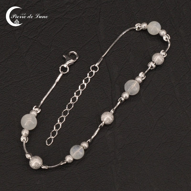Gros plan sur l'alignement des 4 perles de lune polies du Bracelet (Capucine).