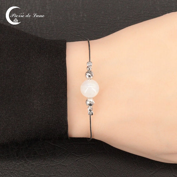 Gros plan sur la perle solitaire 10mm du Bracelet Pierre de Lune (Eos) montrant ses reflets bleutés.