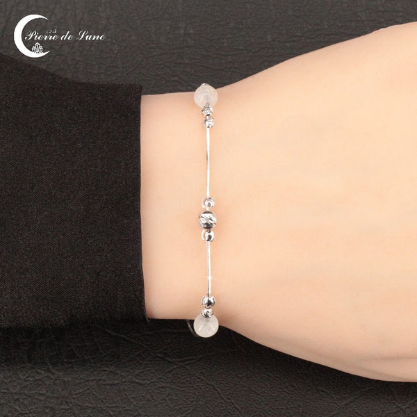 Vue détaillée des trois perles polies et des reflets de lune du Bracelet (Erato).