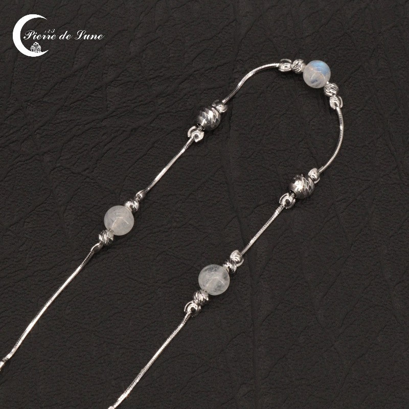 Élégant Bracelet (Erato) hypoallergénique avec trois Pierres de Lune sur fond sobre.