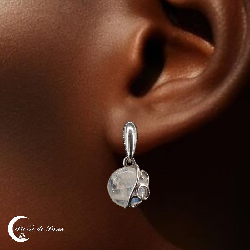 Modèle portant les Boucles d'oreilles Pierre de Lune (Harmonie), soulignant leur taille et leur éclat.