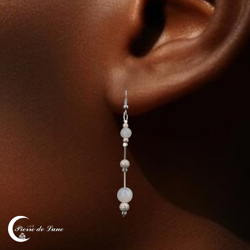 Modèle portant les Boucles d'oreilles Pierre de Lune (Perle) avec deux sphères de tailles différentes.